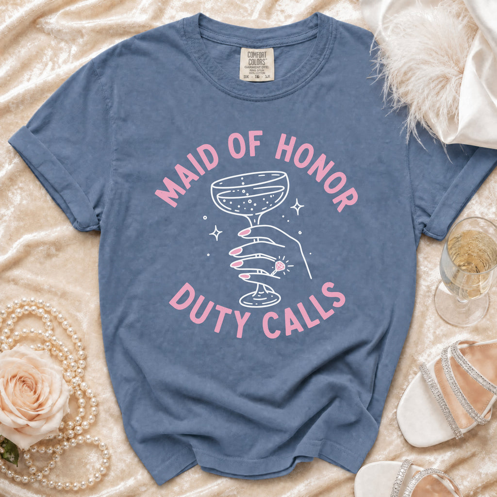 Blue t-shirt with pink text "Maid of Honor Duty Calls" and a champagne glass graphic.