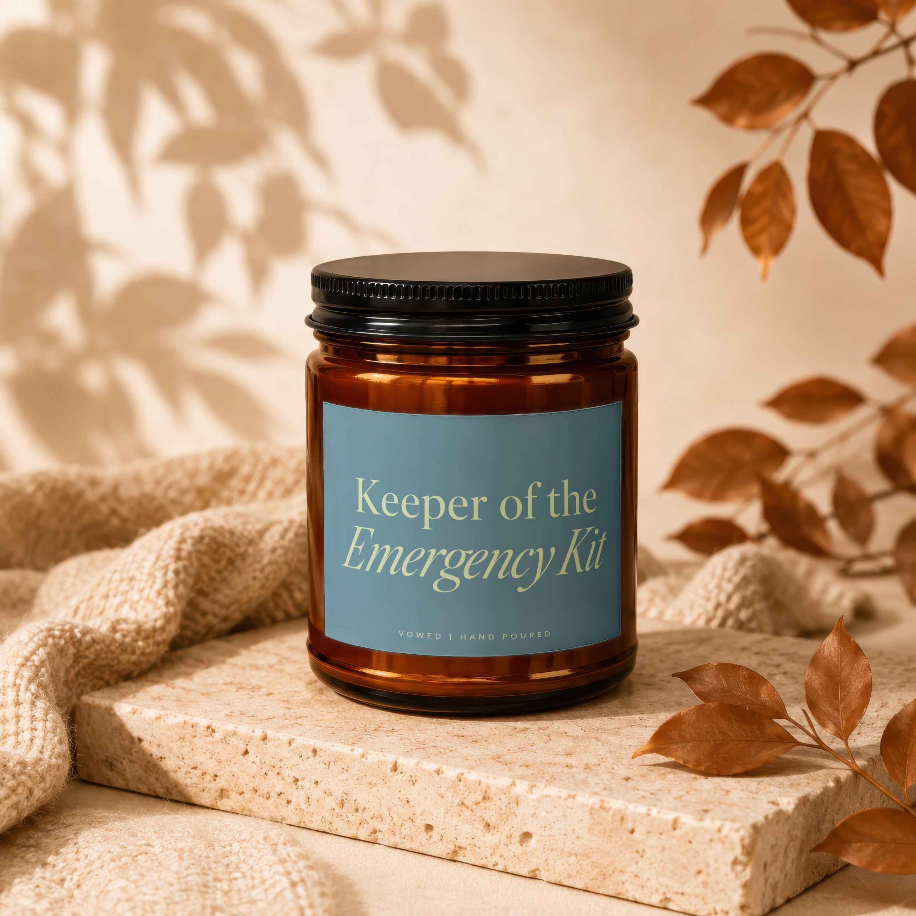 Amber jar candle "Keeper of the Emergency Kit" with a blue label.