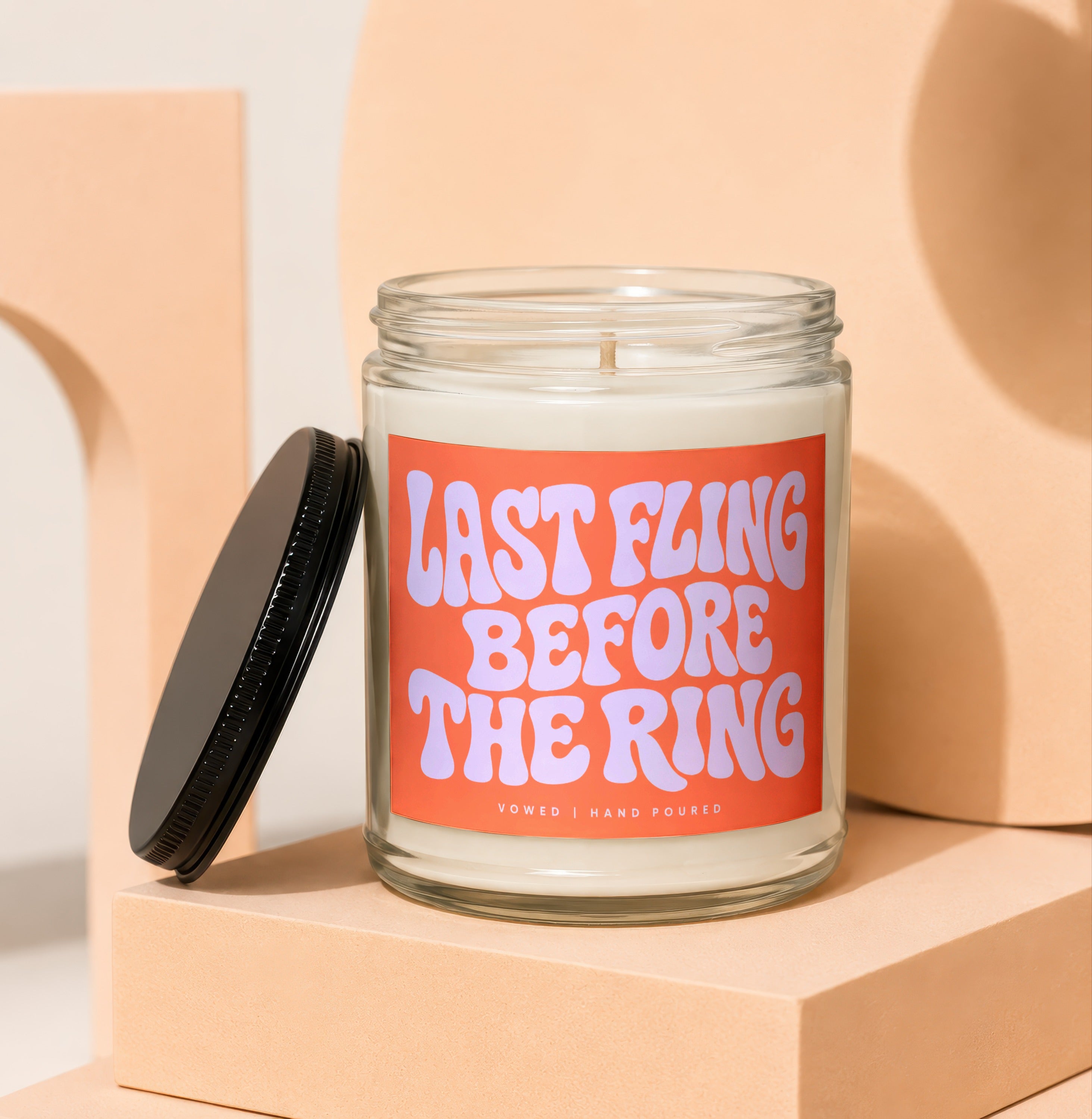 Glass candle with "LAST FLING BEFORE THE RING" text and black lid.