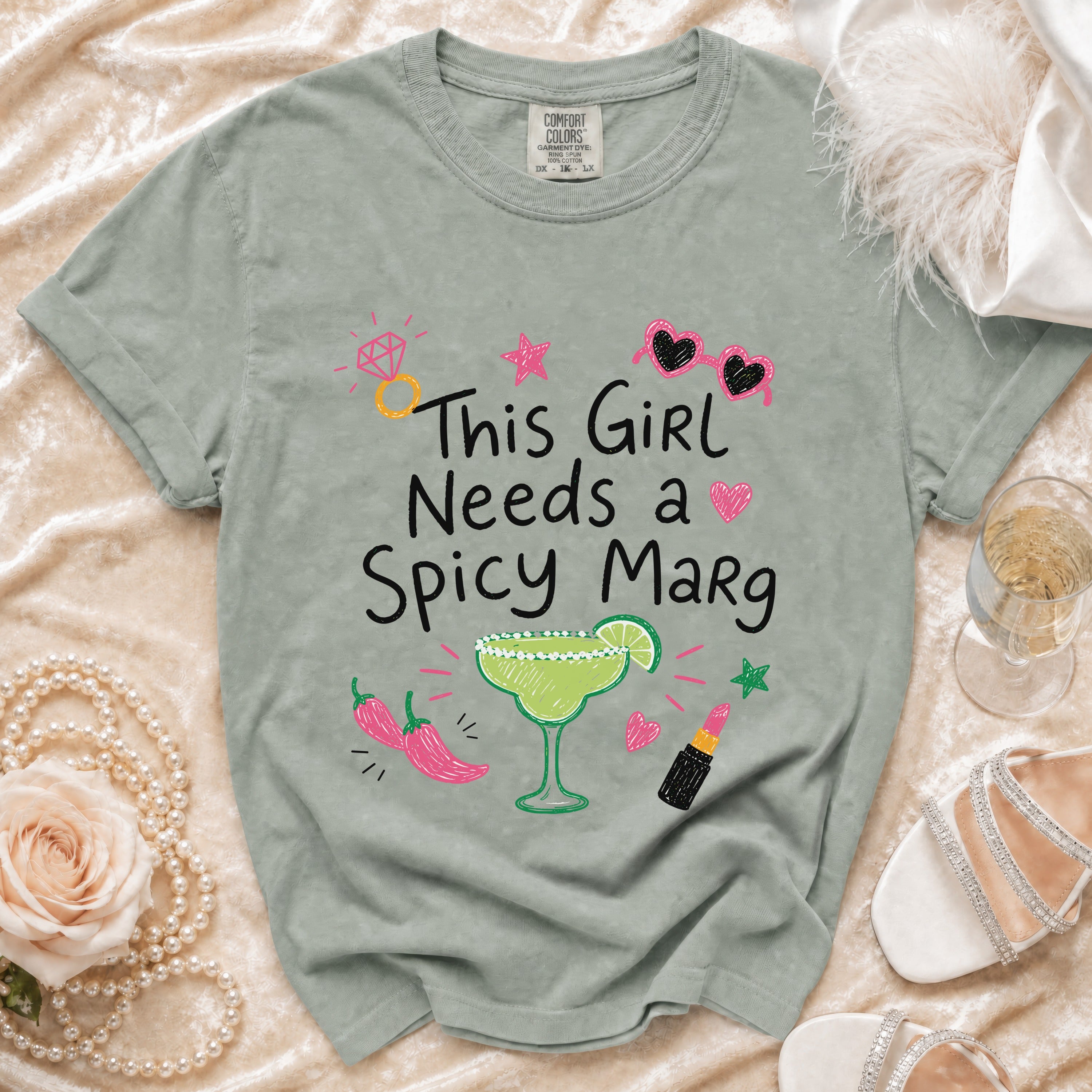 Green t-shirt with "This Girl Needs a Spicy Marg" text and margarita graphic.