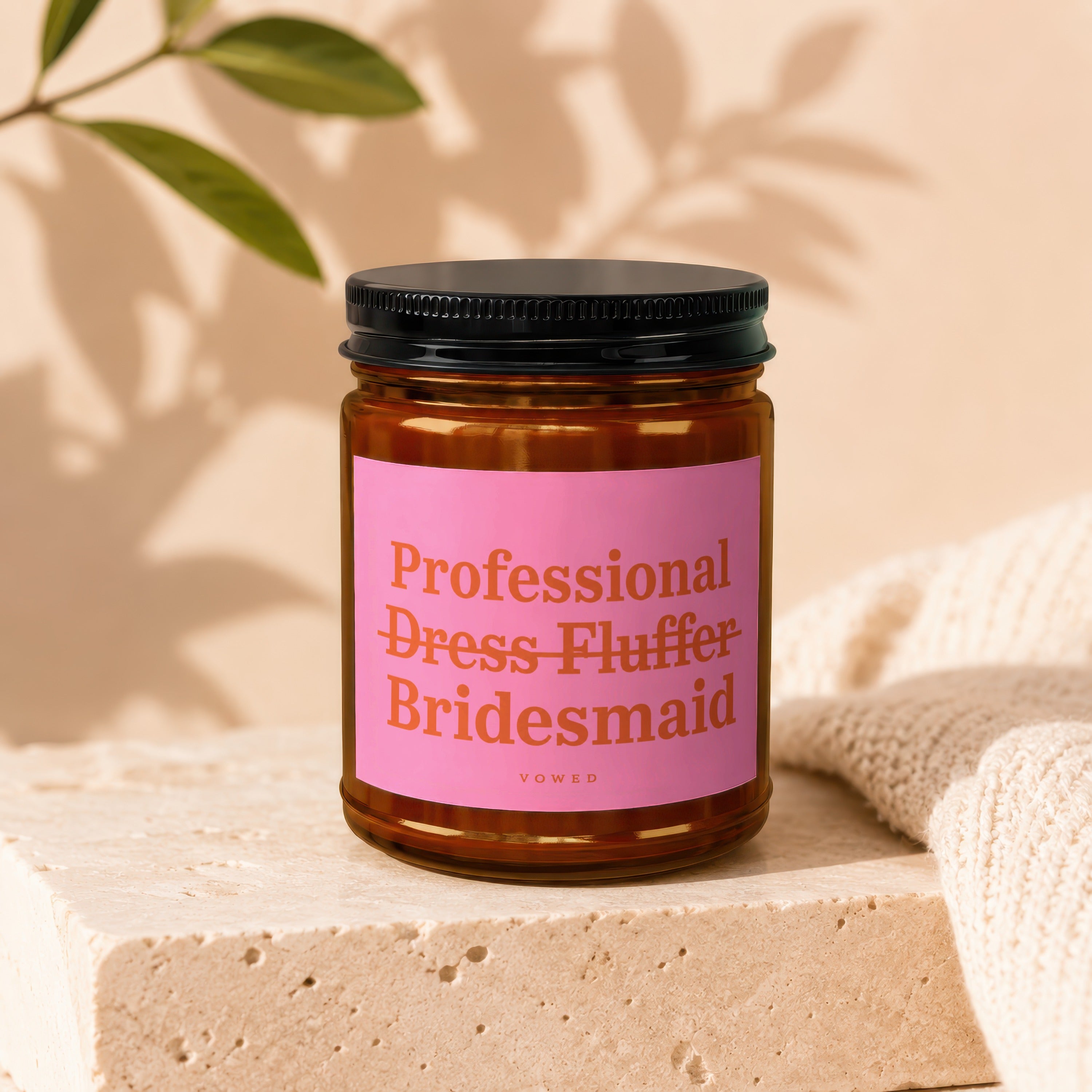 Candle with pink label reading "Professional Dress Fluffer" and "Bridesmaid" by VOWED.