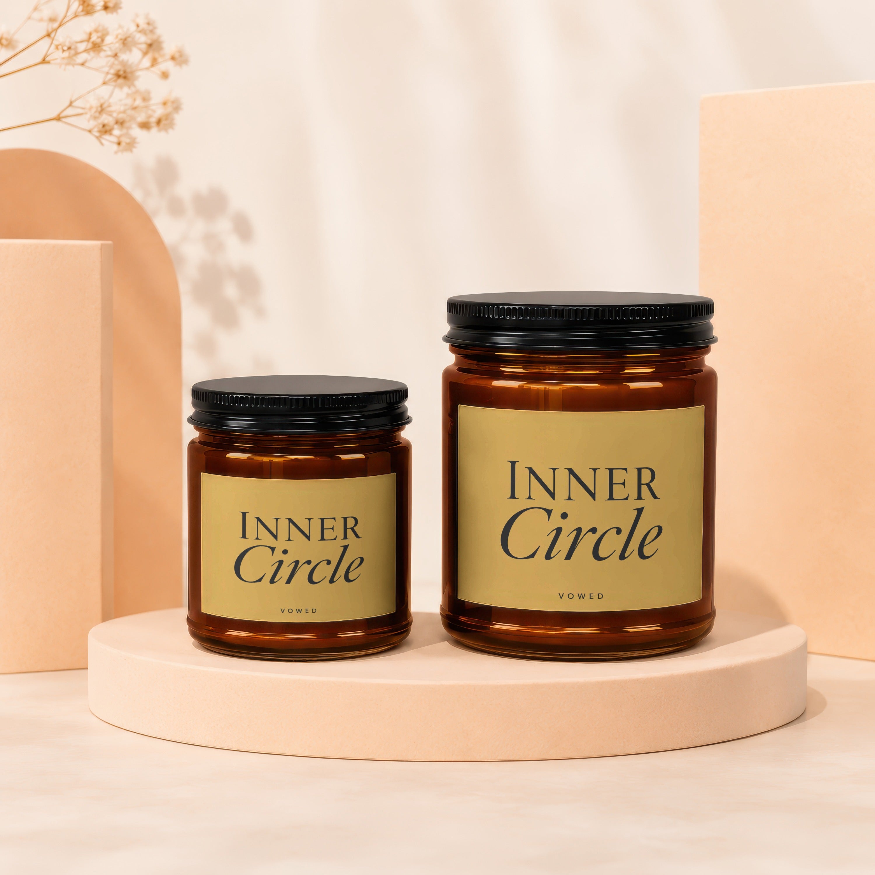 Two amber glass candles with black lids, labeled "INNER Circle VOWED".
