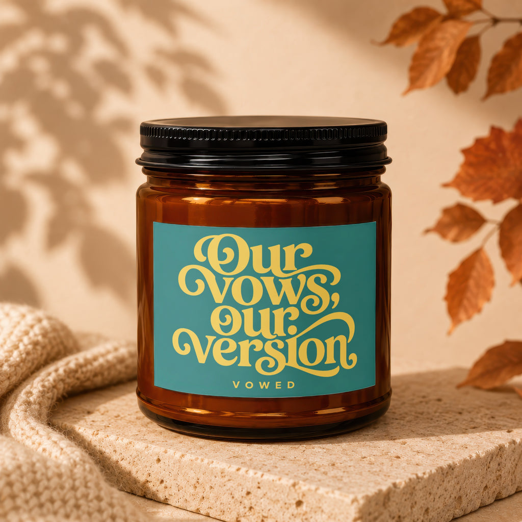 Amber glass candle with a teal label that reads "Our Vows, Our Version VOWED".