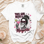 White t-shirt with a bride skeleton holding a margarita, text reads "THIS GIRL NEEDS A Margarita".