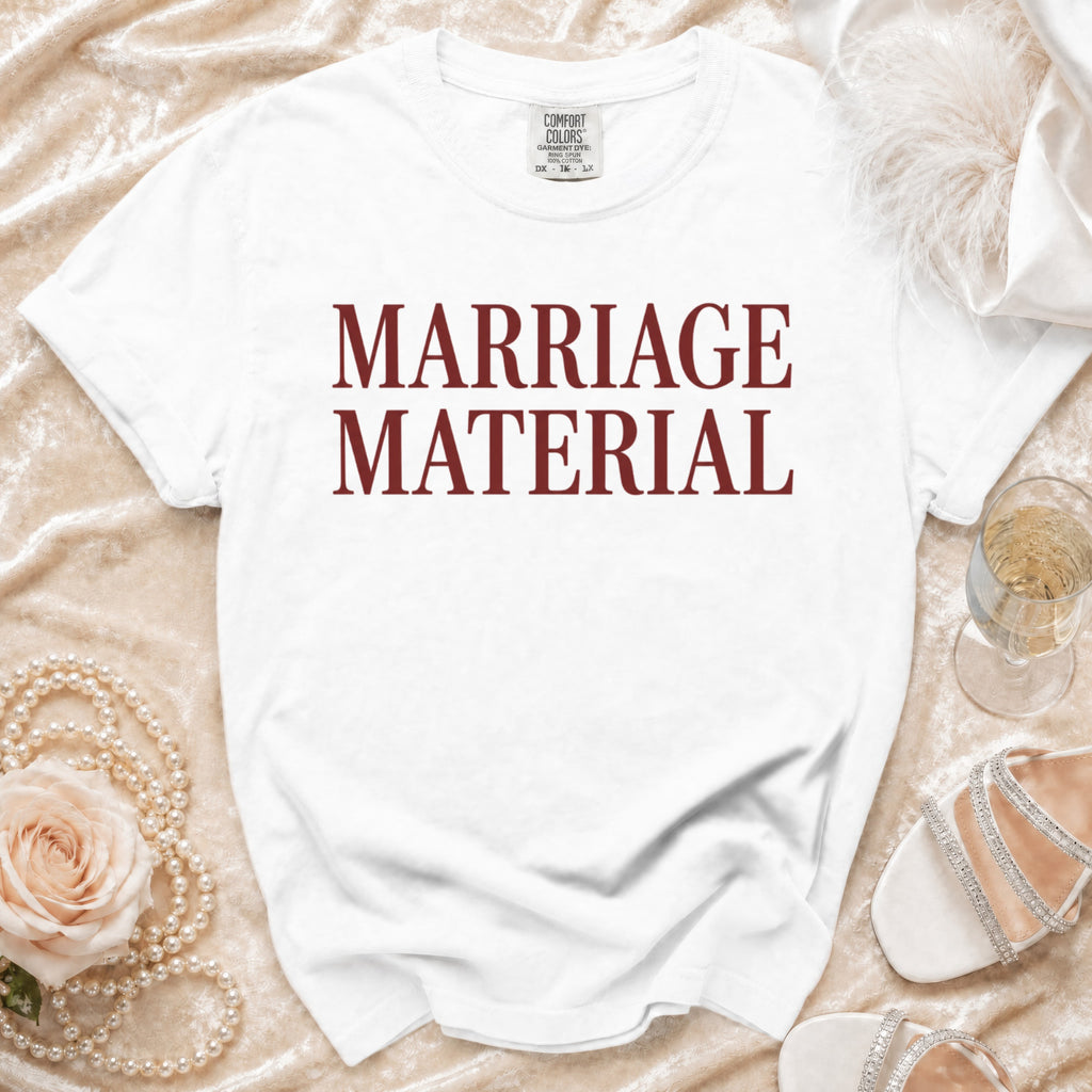 White t-shirt with "MARRIAGE MATERIAL" printed in maroon text.