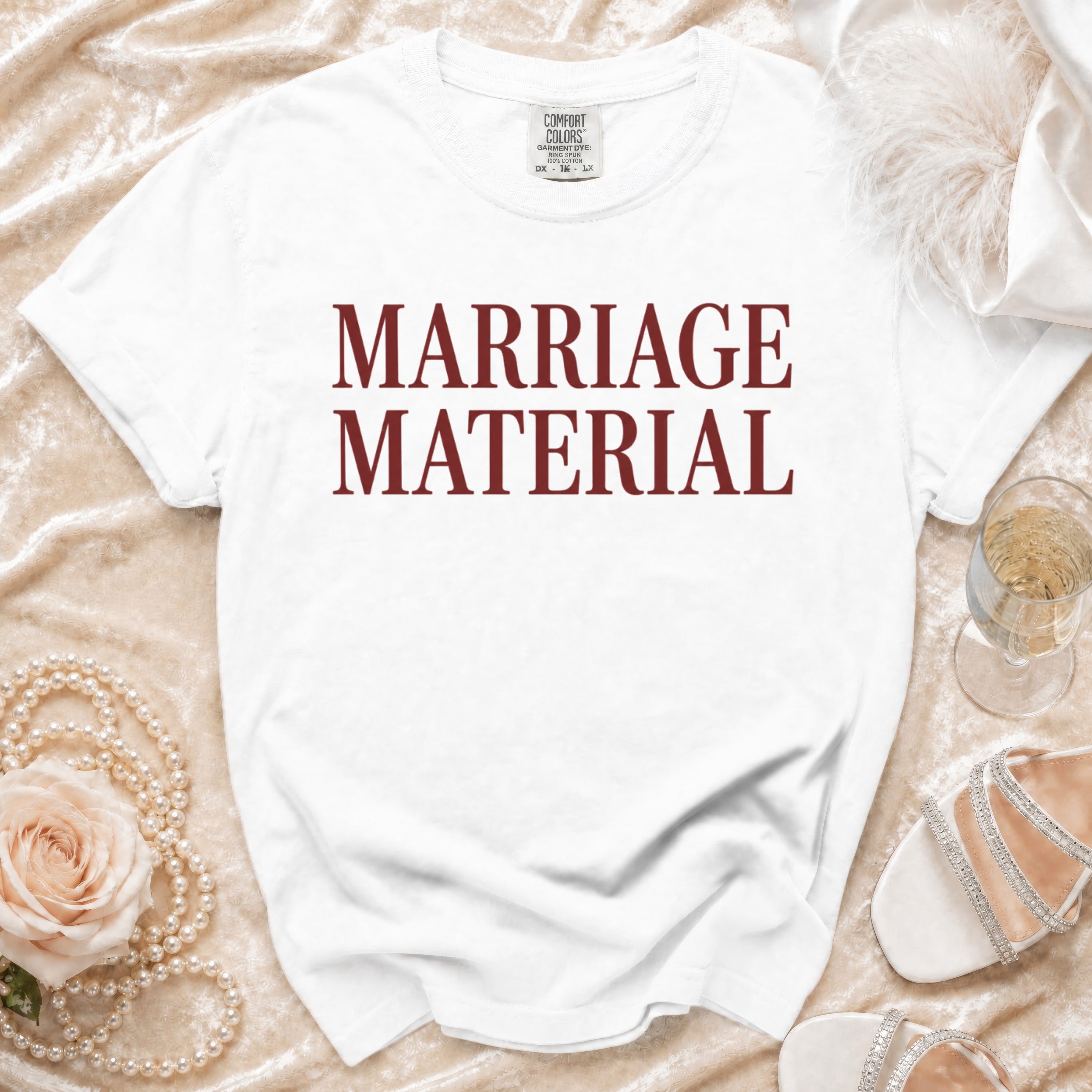 White t-shirt with "MARRIAGE MATERIAL" printed in maroon text.