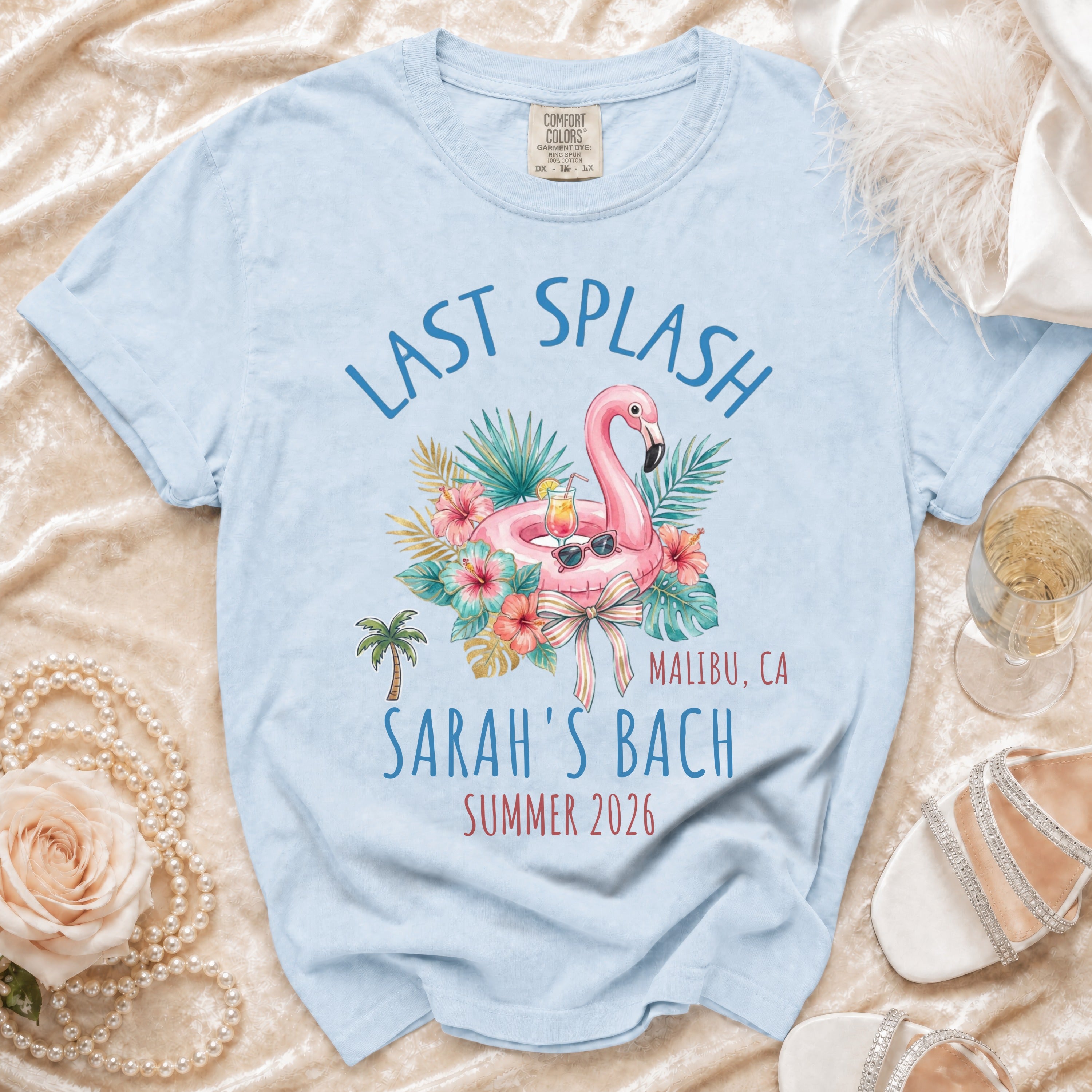 Light blue t-shirt with "Last Splash Malibu, CA Sarah's Bach Summer 2026" text and flamingo graphic.
