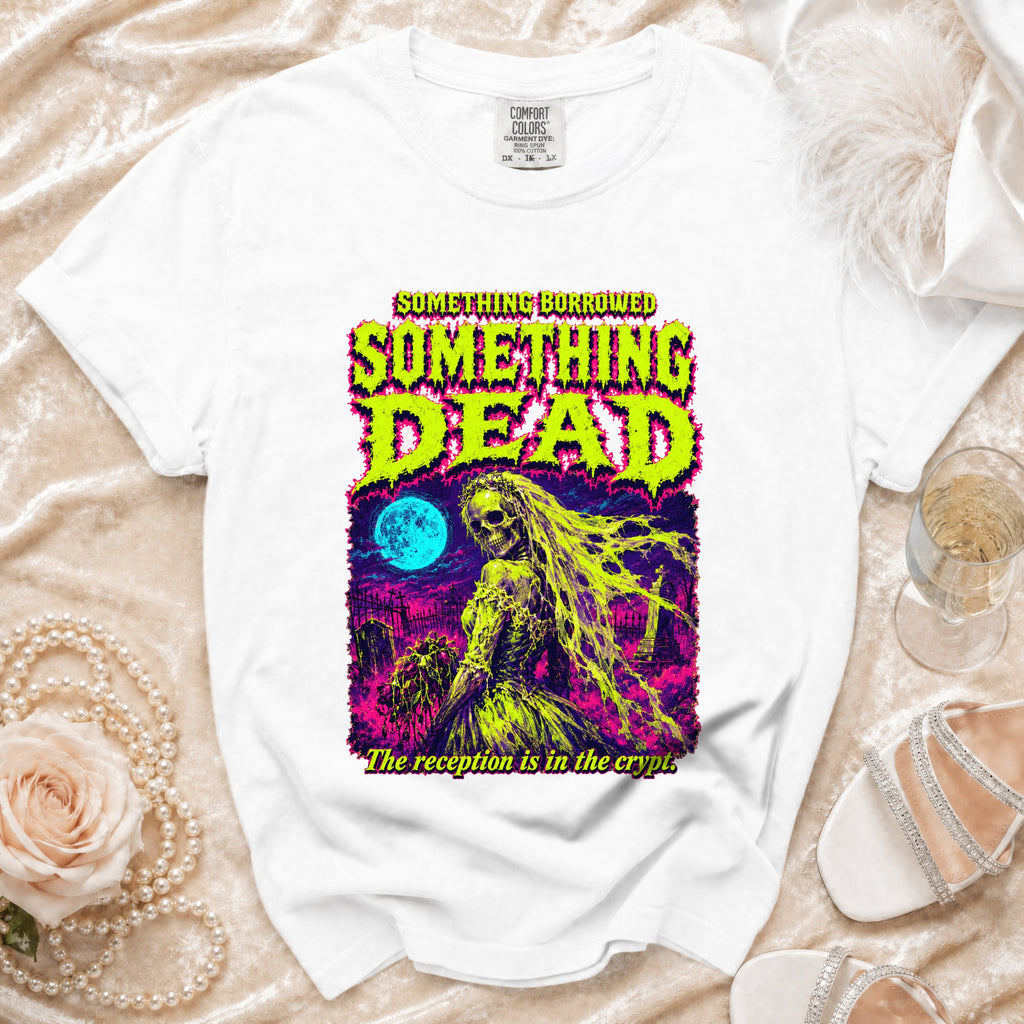 White t-shirt with graphic art of a skeletal bride in a graveyard, with text "SOMETHING BORROWED SOMETHING DEAD".