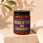 Candle with purple label reading "Smells Like Head B*tch In Charge".