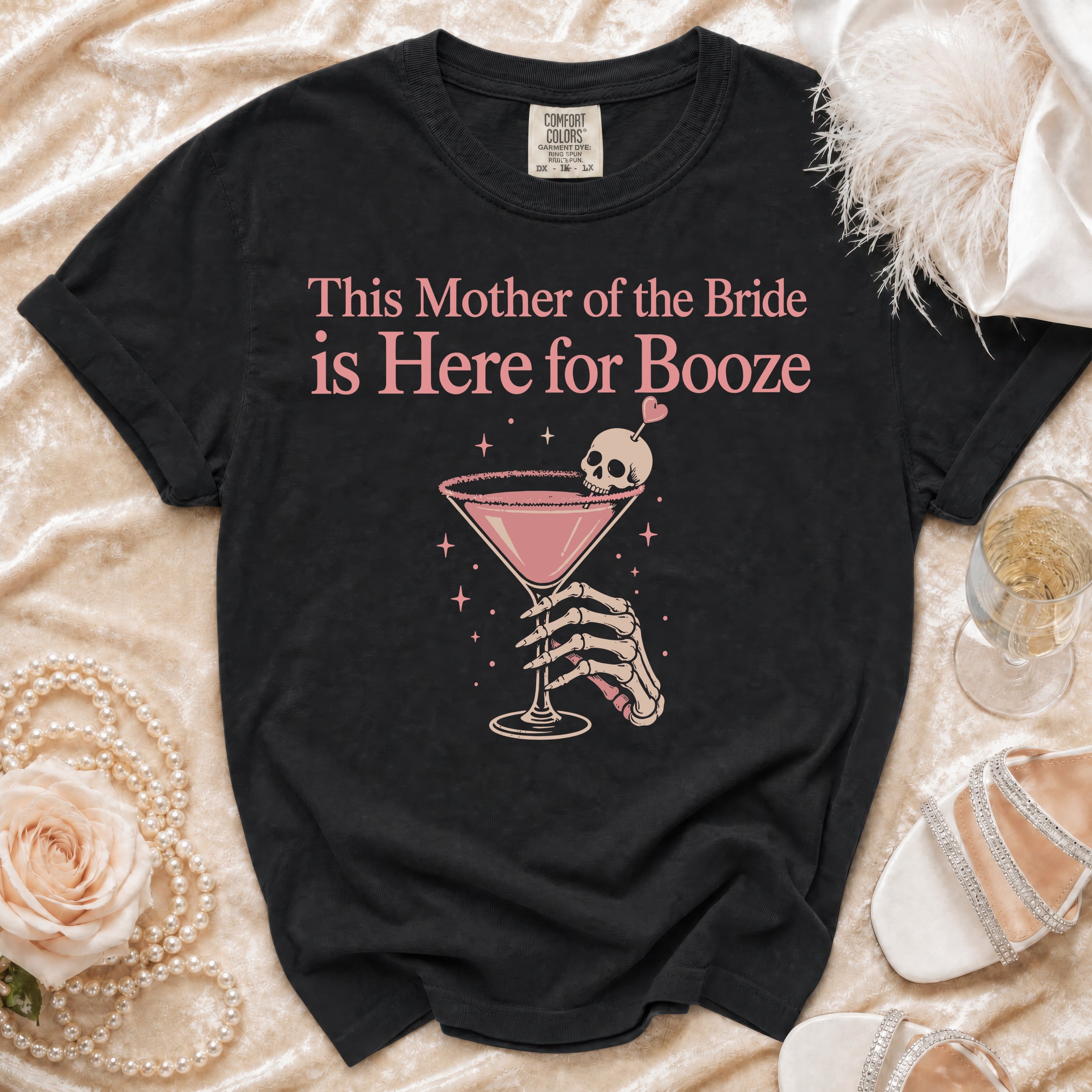 Black t-shirt with "This Mother of the Bride is Here for Booze" text and skeleton hand holding cocktail.