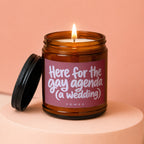 Amber jar candle with lid ajar, label reads "Here for the gay agenda (a wedding)".