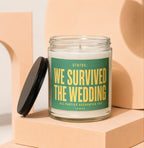 Glass candle with large green label reading "We Survived the Wedding"