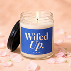 Lit glass jar candle with blue label reading "Wifed Up. VOWED."