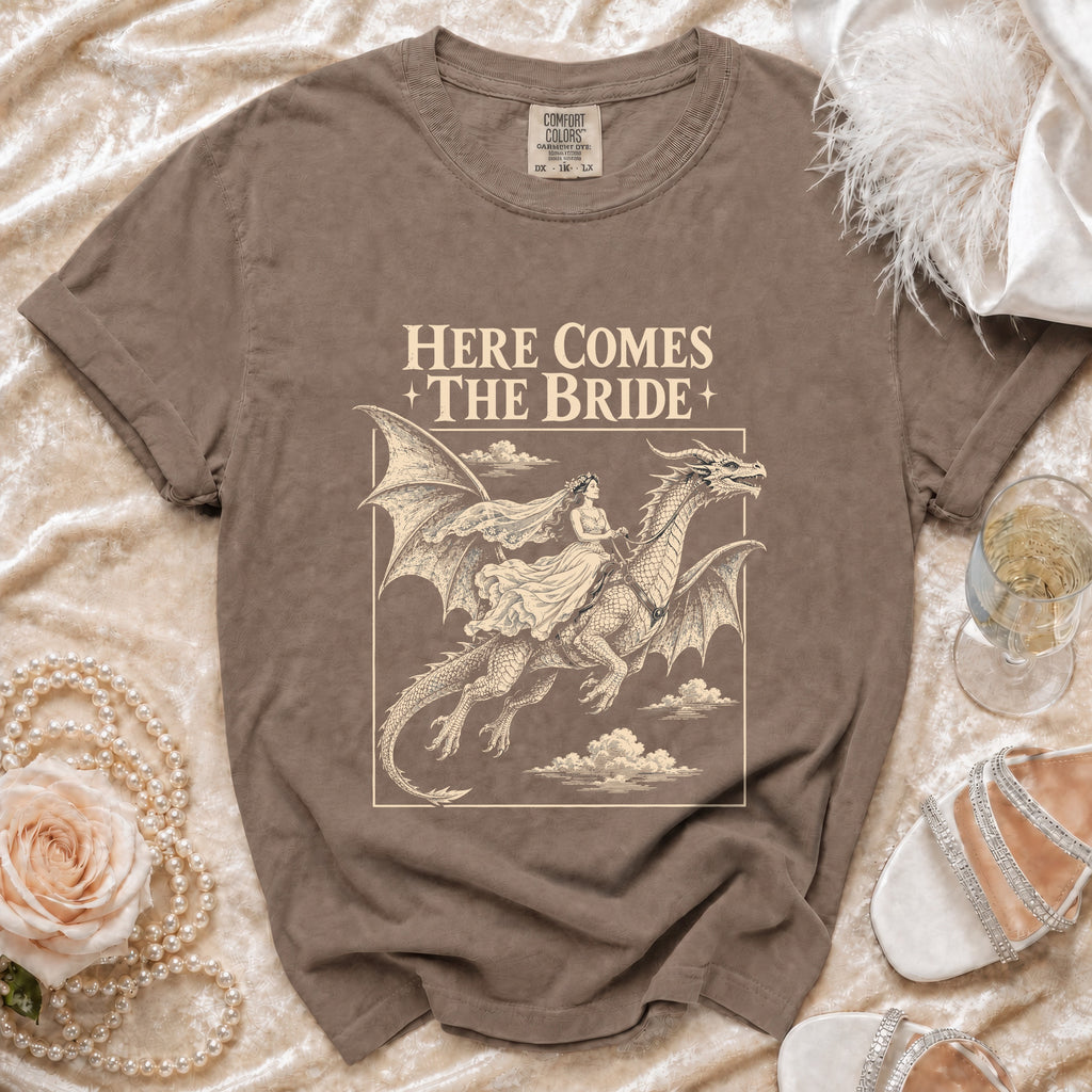 Brown t-shirt graphic: Bride riding a dragon, text "Here Comes The Bride".