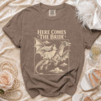 Brown t-shirt graphic: Bride riding a dragon, text "Here Comes The Bride".