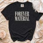 Black t-shirt with "FOREVER MATERIAL" text, styled with pearls and heels.