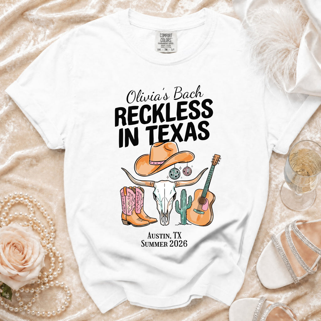 White t-shirt with "Olivia's Bach Reckless in Texas" and Austin graphics.
