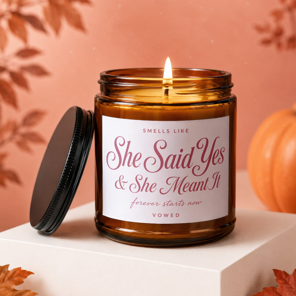 Amber jar candle with "She Said Yes & She Meant It" text, lit.