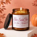 Amber jar candle with "She Said Yes & She Meant It" text, lit.