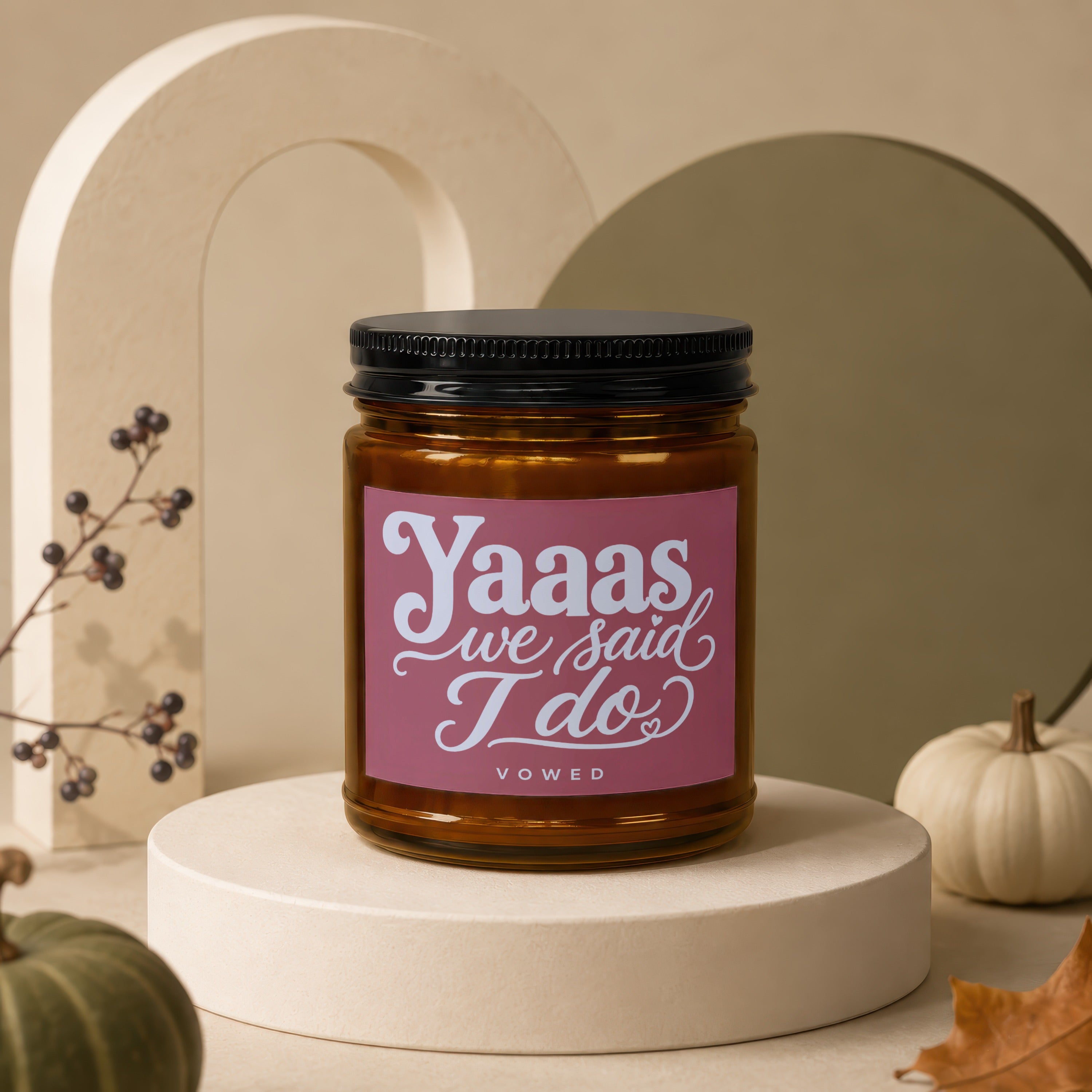 Amber jar candle with pink label reading "Yaaas we said I do" and "vowed".
