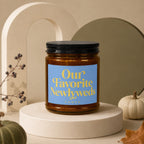 Amber candle in glass jar with black lid, labeled "Our Favorite Newlyweds Vowed".
