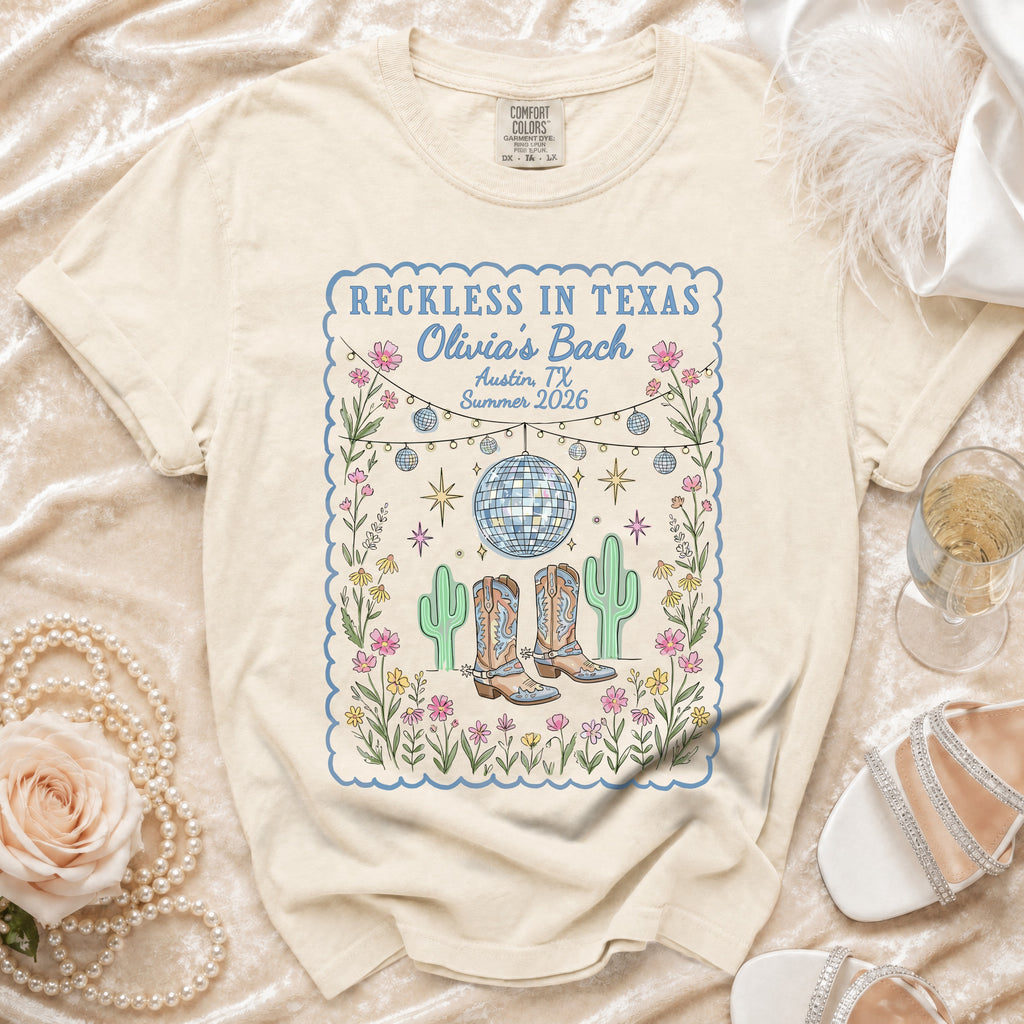 Cream t-shirt with "Reckless in Texas Olivia's Bach Austin, TX Summer 2026" design.