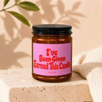 Brown glass candle with pink label reading "I've Been Given Earned This Candle. VOWED".
