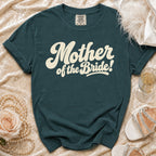 Teal t-shirt with "Mother of the Bride!" text in cream script font.