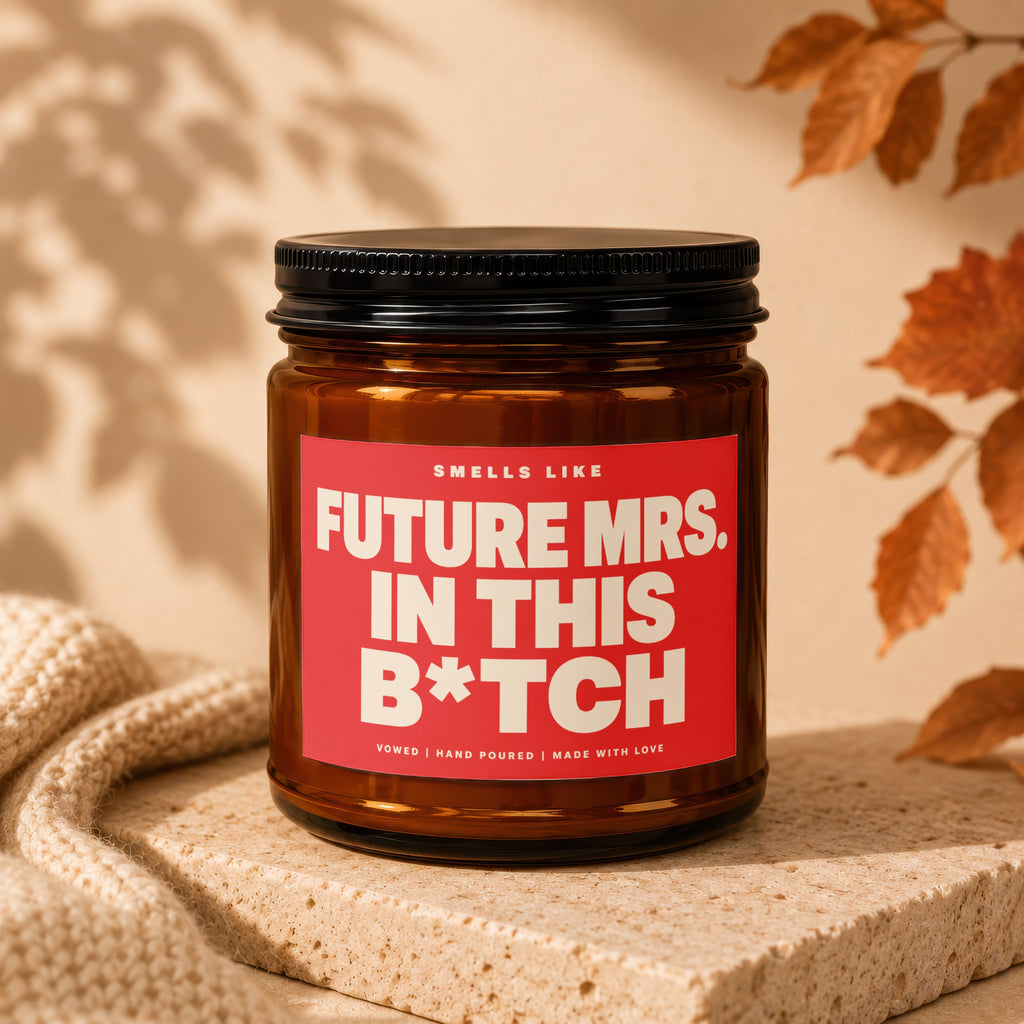 Brown glass candle with red label reading "Smells like Future Mrs. in this B*tch".
