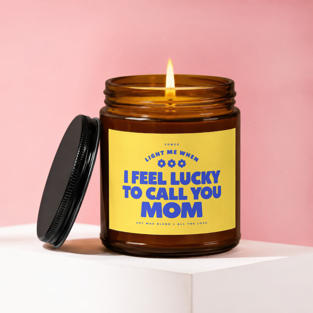 Amber jar candle with lit flame, reads "I feel lucky to call you Mom."