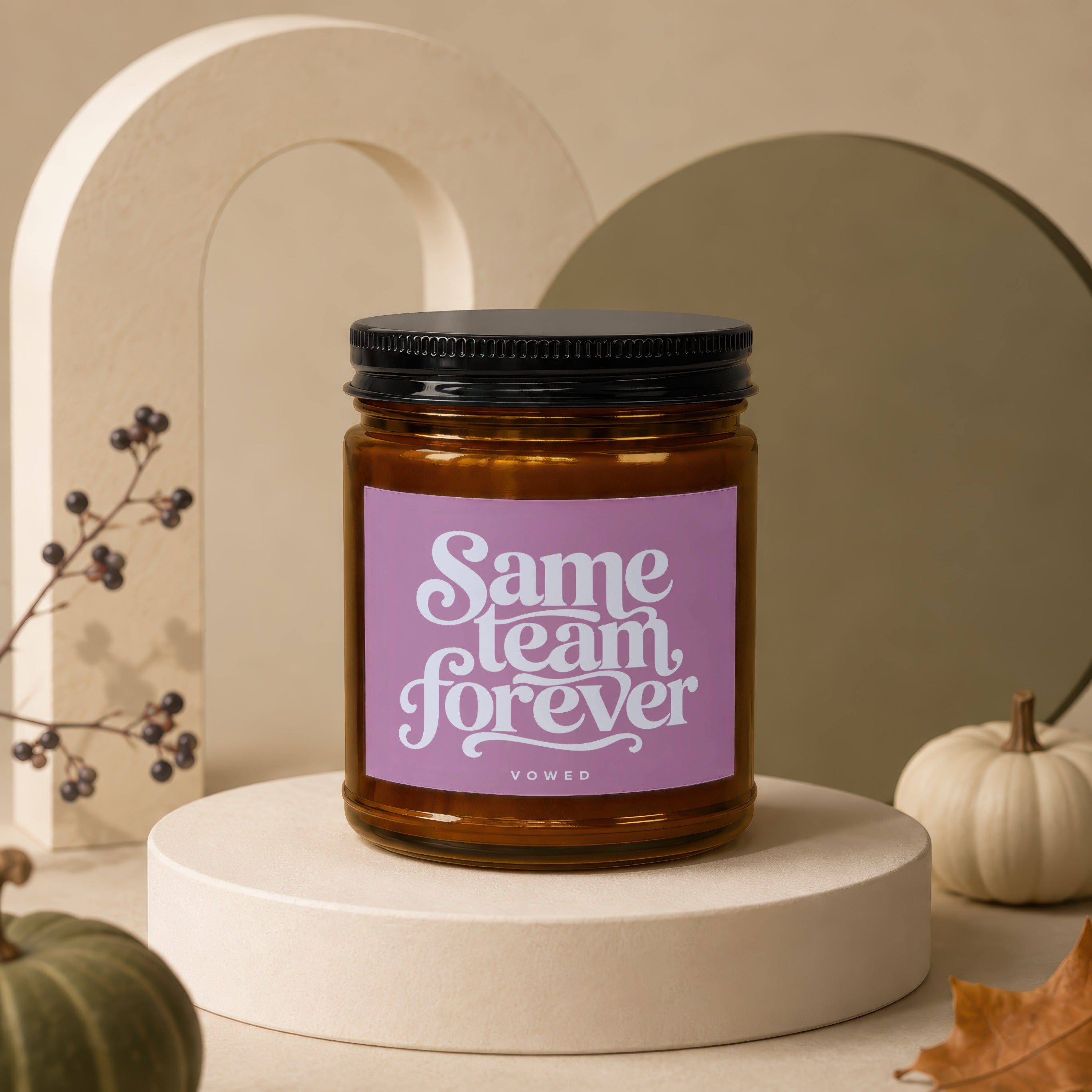 Amber candle with "Same team forever vowed" text on pink label.