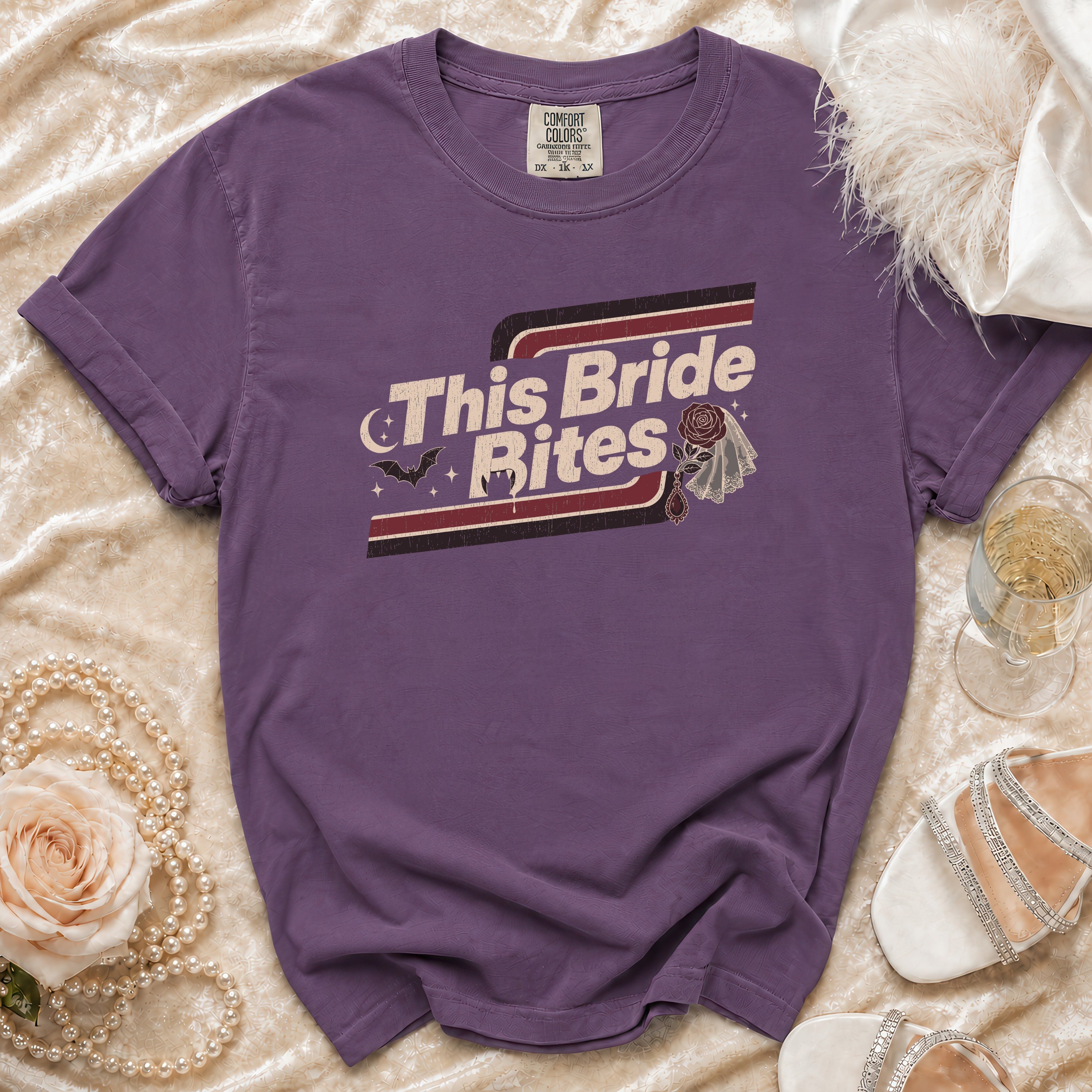 Purple t-shirt with "This Bride Bites" text, bat, and veil graphic.