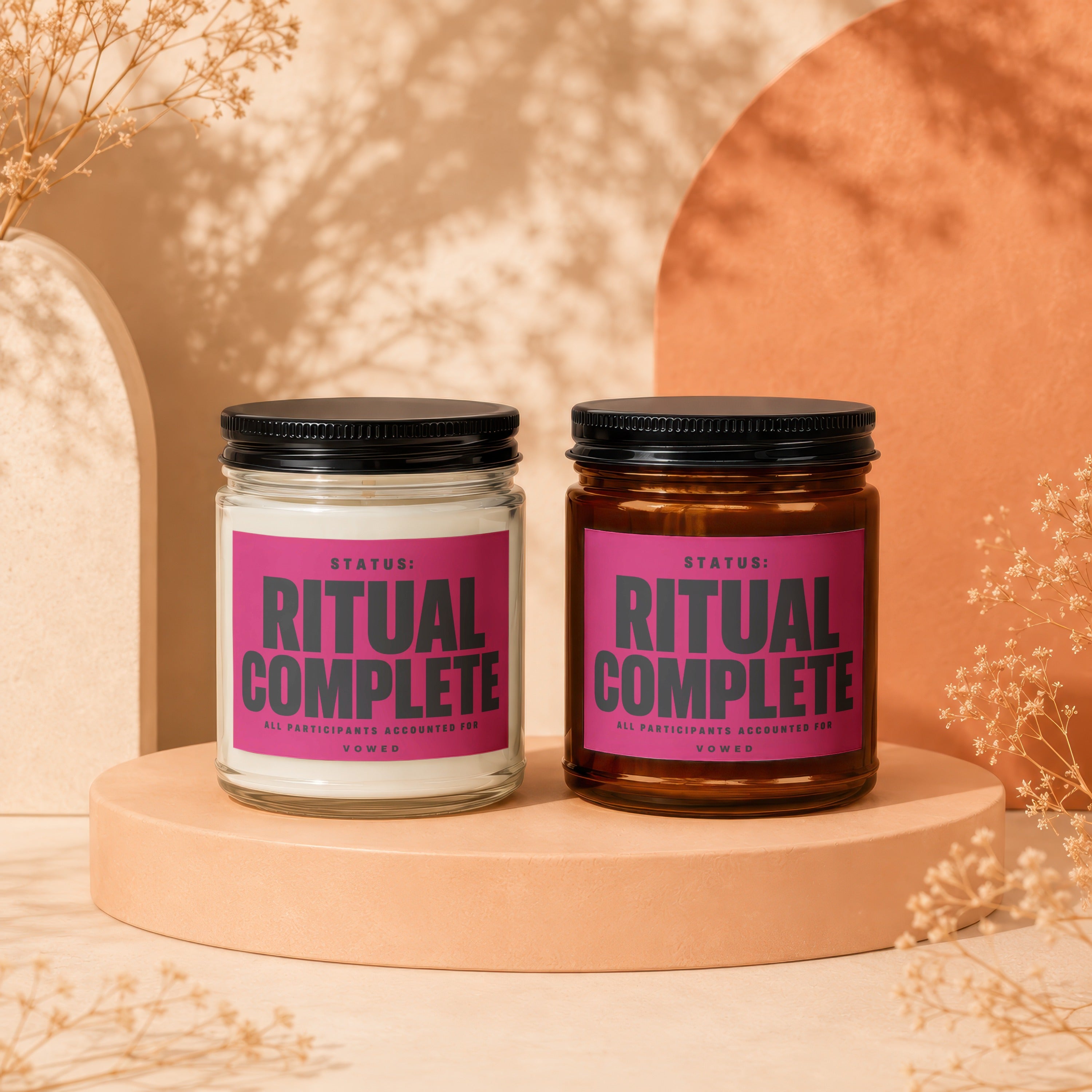 Two candles with pink labels reading "Ritual Complete" displayed on pedestals.