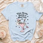Light blue t-shirt with skeleton bride graphic and "This Bride Needs a Martini" text.