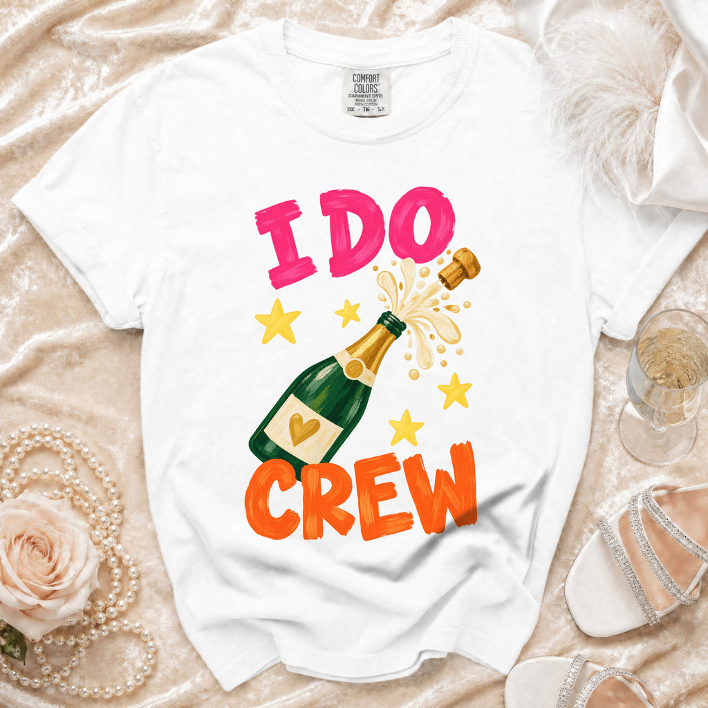White t-shirt with "I DO CREW" text and a champagne bottle graphic.