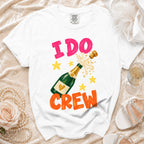 White t-shirt with "I DO CREW" text and a champagne bottle graphic.