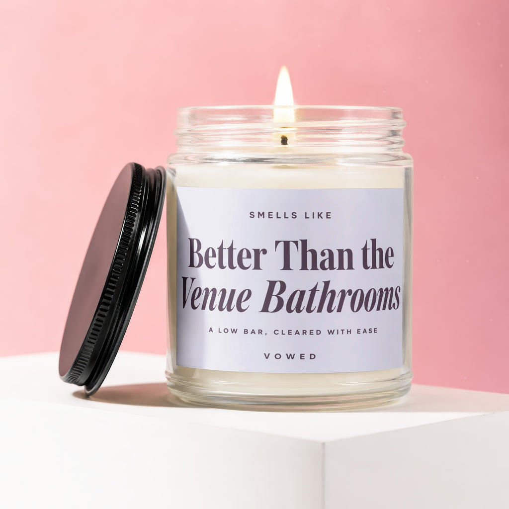 Jar candle with a lit wick and label reading "Better Than the Venue Bathrooms."