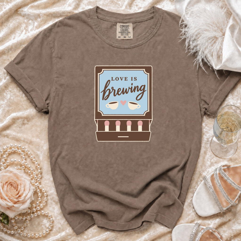 Brown t-shirt with "Love is Brewing" text and coffee cups graphic.