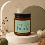 Amber candle with black lid and "it's giving bride" text on label.