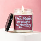 Glass jar candle with "Two brides, no groom, no problem" text on a pink background.