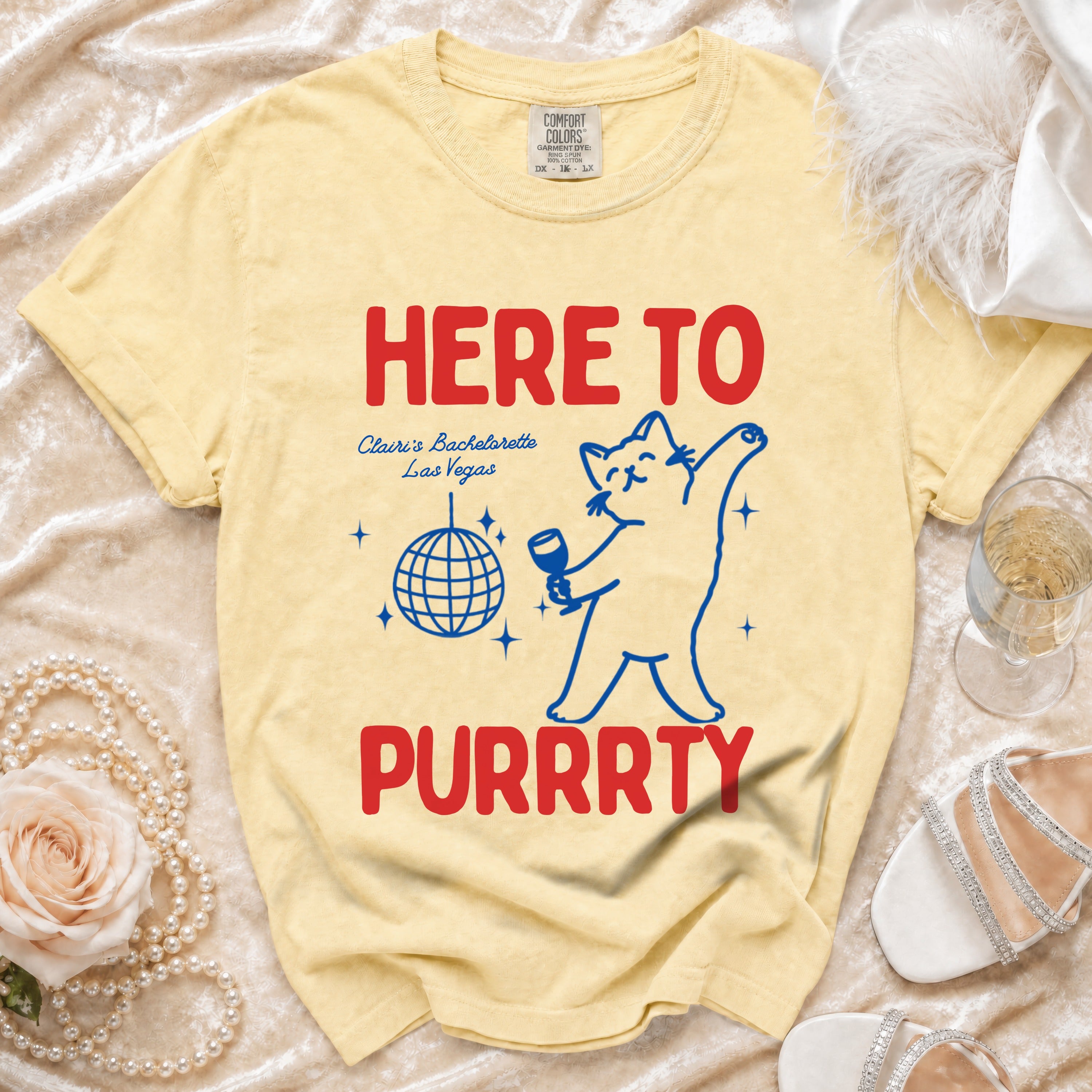 Yellow shirt with cat graphic, reading "HERE TO PURRRTY Clairi's Bachelorette Las Vegas".