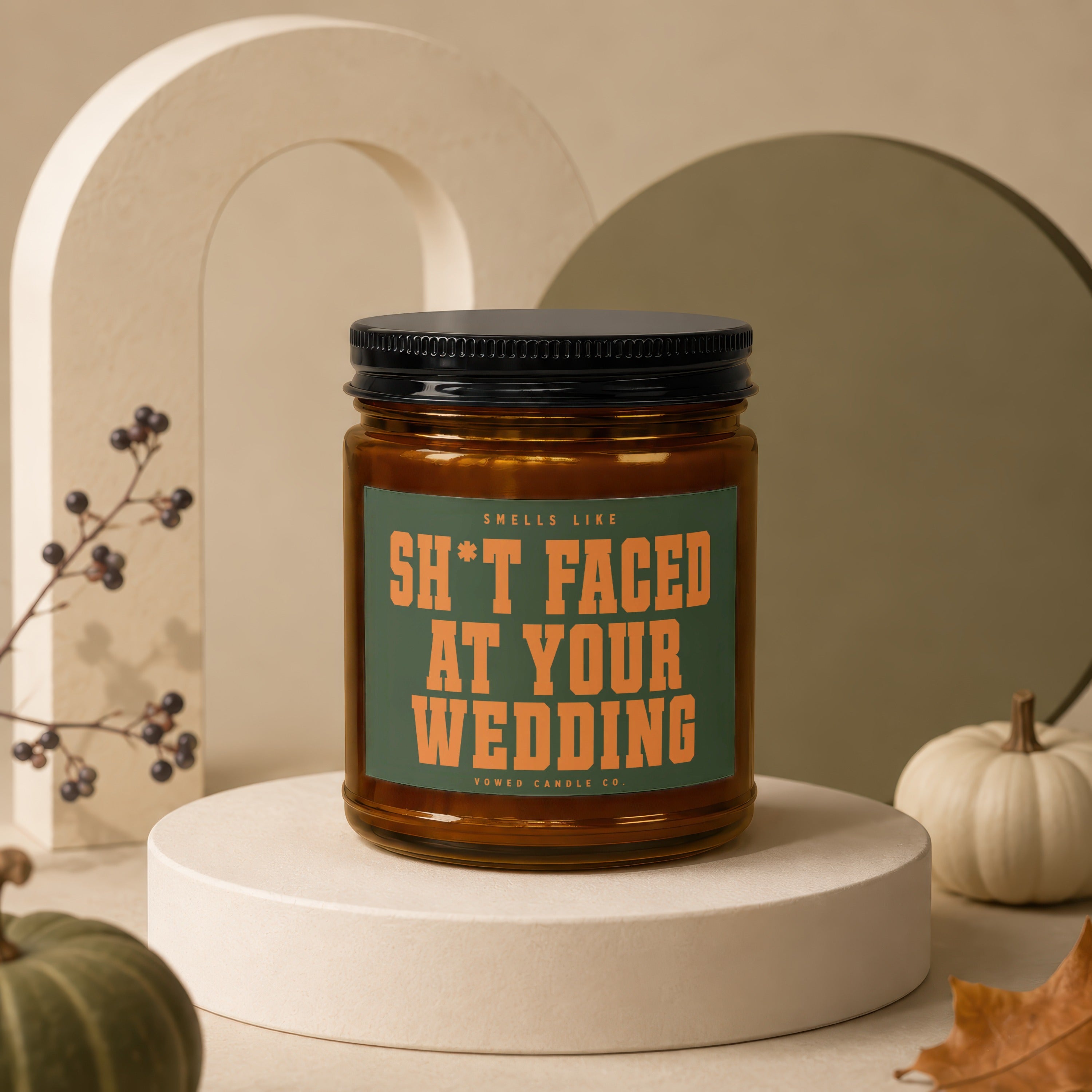 Amber candle with a green label reading "Smells Like Sh*t Faced At Your Wedding."
