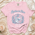 Pink t-shirt with "Reckless in Texas" and western graphics, Austin TX Summer 2026.
