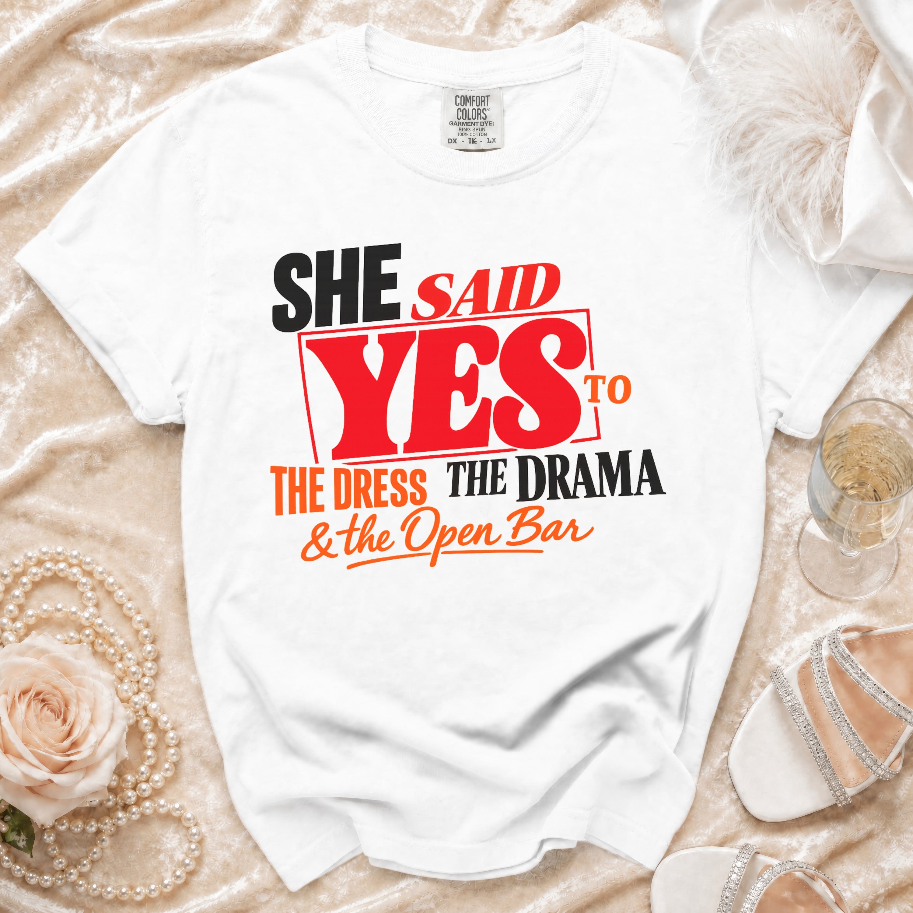 White t-shirt with "She Said Yes to the Dress, The Drama & the Open Bar" graphic.
