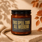 Amber candle with black lid, "This Spell Took All Weekend" text on label.