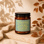 Amber jar candle with black lid, featuring "Forever Looks Good" and "vowed" text.