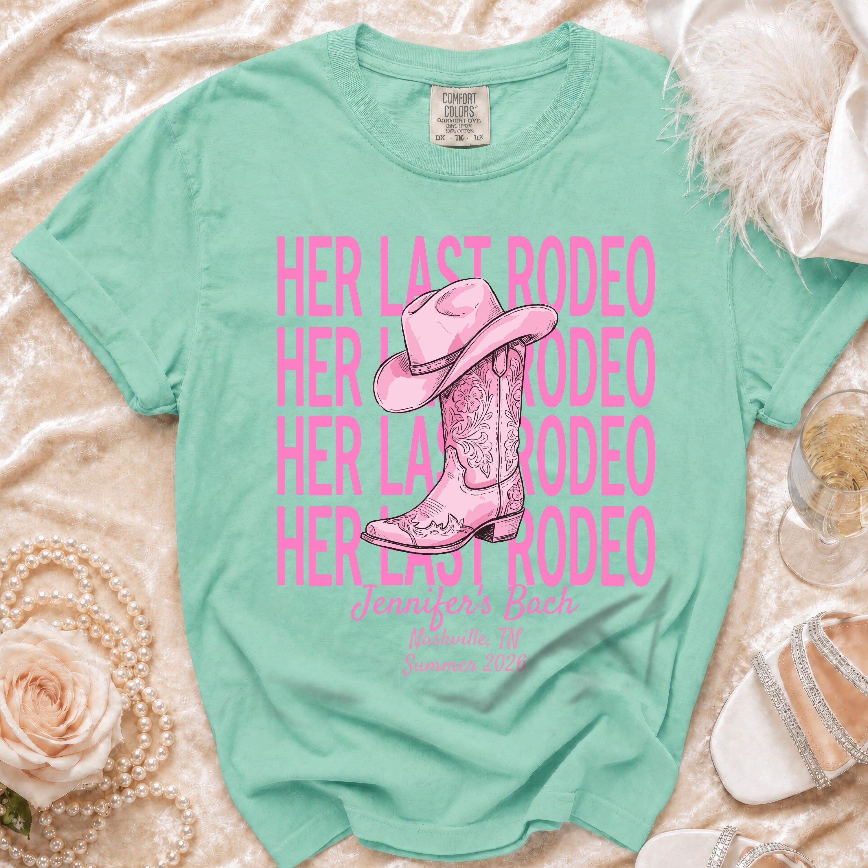 Pink cowboy boots and hat on "Her Last Rodeo" t-shirt with text.