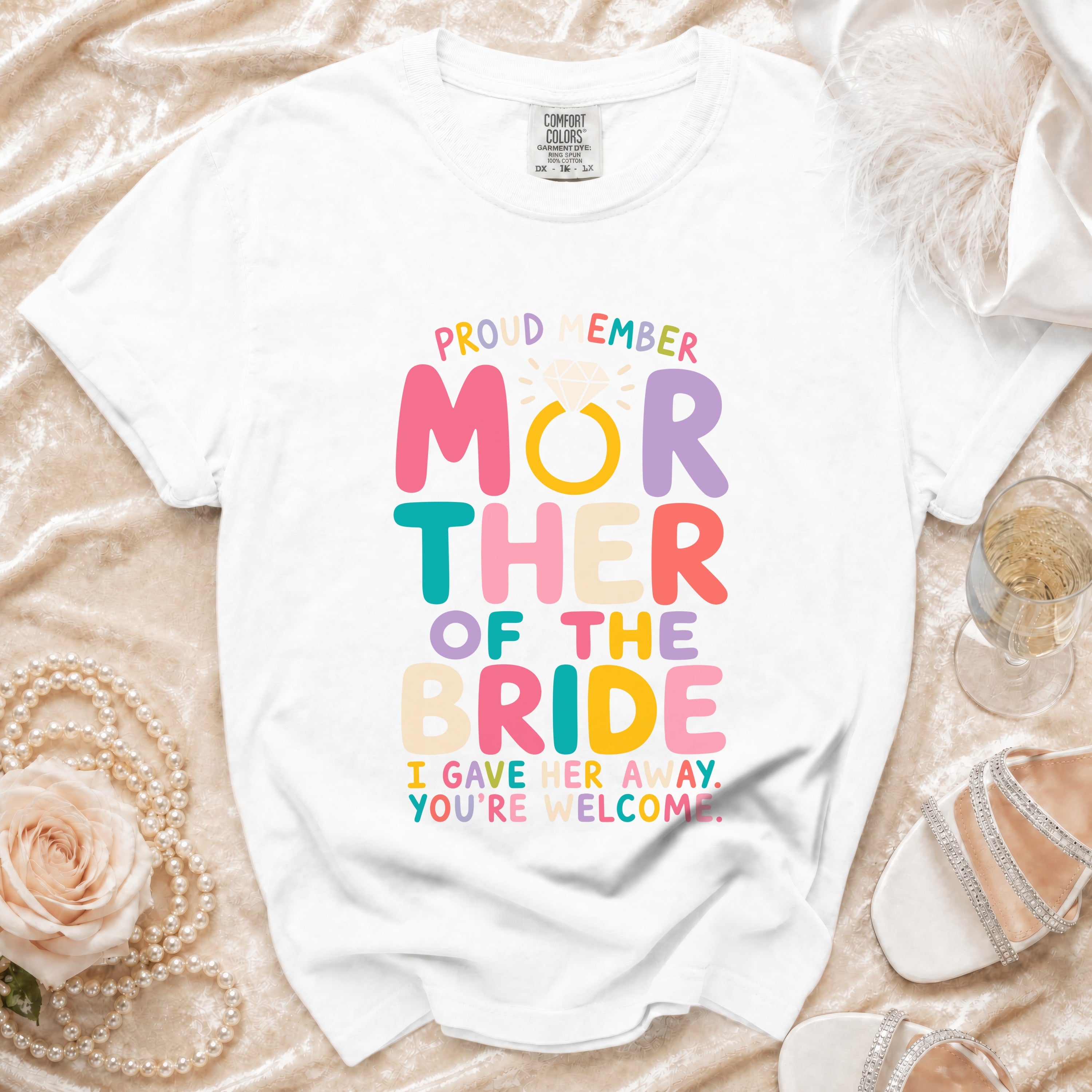 White t-shirt with "Proud Member Mother of the Bride I Gave Her Away. You're Welcome." text.