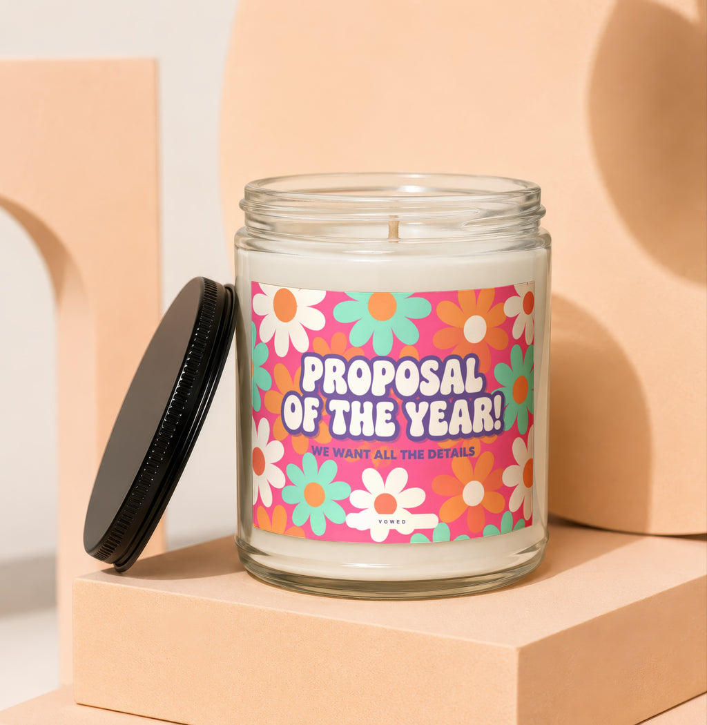 Glass candle with "Proposal of the Year! We Want All The Details" text and floral design.