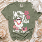 Green t-shirt with "Mother of the Bride Spooky & Proud" text and a ghost graphic.